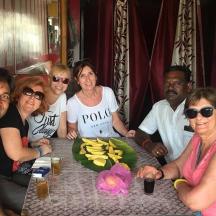 a group of people sitting at a table with bananas