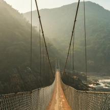 un pont penjant sobre un riu a la muntanya