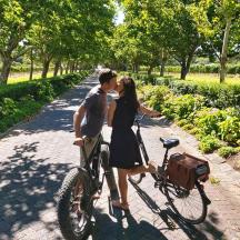 a man and a woman kissing next to a bike