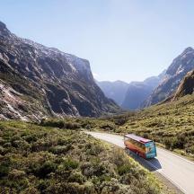 a bus driving down a road in a canyon
