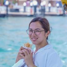 a woman with glasses eating a piece of food