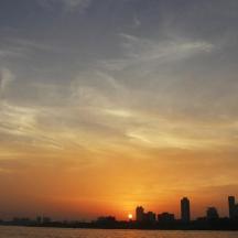 a city skyline at sunset with the sun setting