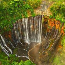 an aerial view of a waterfall in a forest