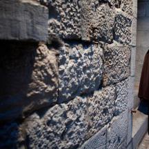 a woman standing next to a brick wall