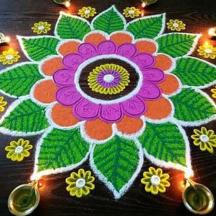 a rangoli of a flower on a table with lights