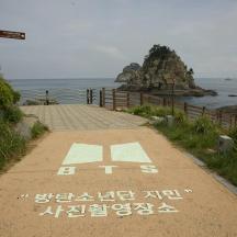 a path with writing on it next to the ocean