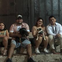 sekelompok orang duduk di tangga bersama anjing mereka