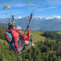 zwei Personen fliegen mit einem Fallschirm durch die Luft