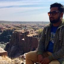 a man sitting on the edge of a canyon