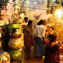 a group of people standing around a store with vases