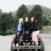 tres dones assegudes a la part posterior d'un camió