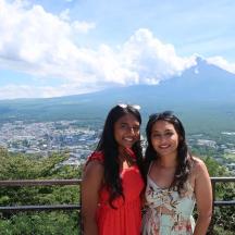 two women posing for a picture in front of a mountain