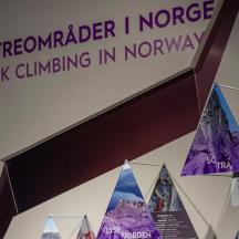 a sign for a rock climbing museum with flags