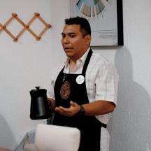 en mand i et forklæde, der holder en sort blender