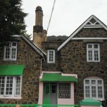 an old stone house with white windows and green shutters