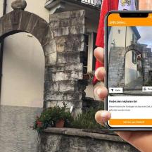 seseorang yang memegang telefon bimbit di hadapan sebuah bangunan