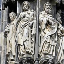 una estatua de tres hombres en el costado de un edificio