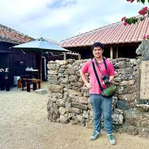 a man standing in front of a stone wall