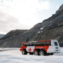 a red and white bus parked in the snow
