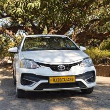 a white car parked in front of a tree
