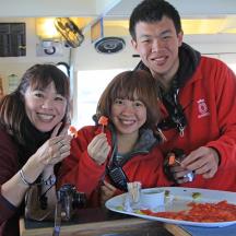 three people sitting at a table with a plate of food