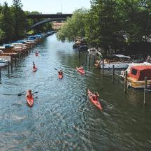 a group of people kayaking down a river with boats