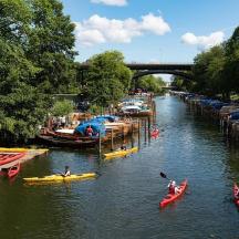 a group of people kayaking down a river with boats