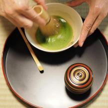 a person is stirring a bowl of green liquid