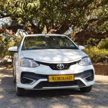 a white car parked in front of a tree