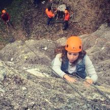 una donna con un casco arancione sdraiata su alcune rocce