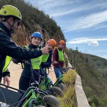 three men in yellow vests taking a picture with their bikes
