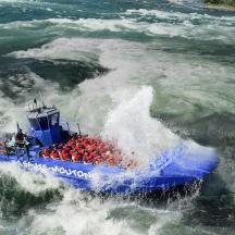 a blue boat in a wave in the water