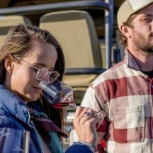 a man and woman drinking wine from wine glasses