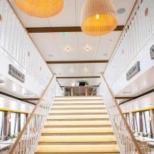 una scala in un edificio con tavoli e sedie