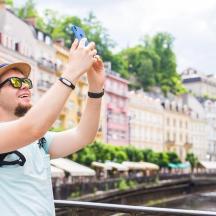 a man taking a picture of a city with his cell phone