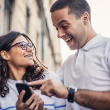a man and a woman looking at a cell phone