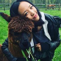una dona sosté un animal marró en un camp