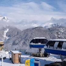 a ski resort with a ski lift with snow covered mountains