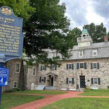 a sign in front of a large stone building