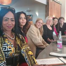a group of women standing around a bar