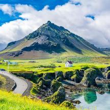 a mountain in the distance with a road and a river