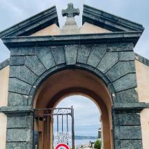 ein Tor zu einem Gebäude mit einem Kreuz darüber
