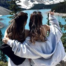 Zwei Frauen stehen auf einem Berg und blicken auf einen See