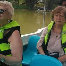 two women sitting in a boat on the water