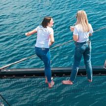 two women standing on a boat in the water
