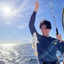 ein Mann, der auf einem Boot einen Fisch in der Hand hält