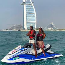 a man and woman standing on a jet ski in the water