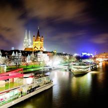Eine Stadt bei Nacht mit Booten auf dem Wasser
