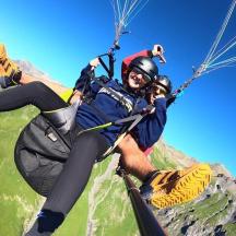 un home muntant un parapent davant d'una muntanya