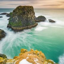 a view of the ocean with rocks in the water